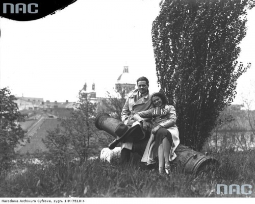 Aktorzy Eugeniusz Bodo i Nora Ney podczas zwiedzania Krakowa, na wzgórzu wawelskim siedzą na lufie armatniej. Kraków_05.1933 r.